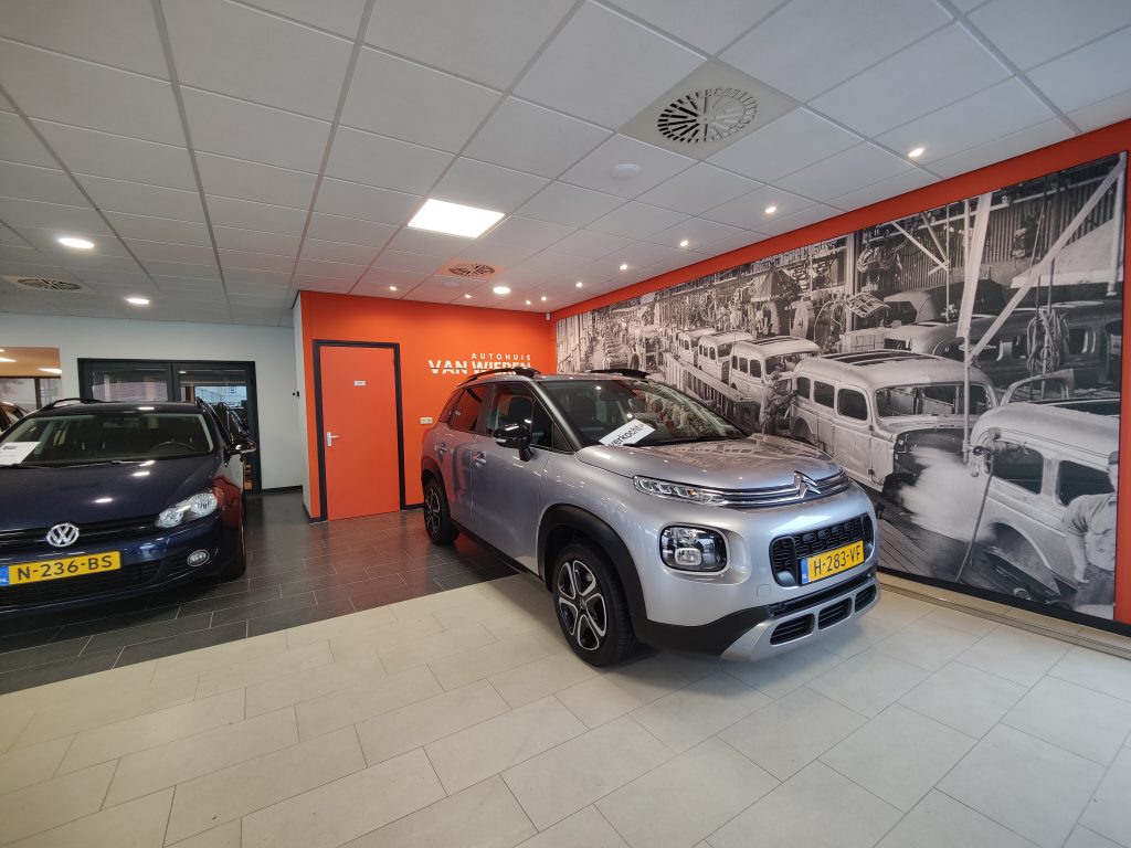 De showroom met een Citroën C3 Aircross voor de oranje wand met het logo