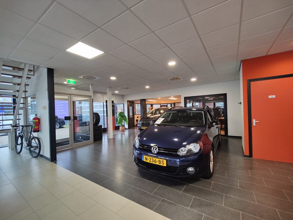 De showroom met een blauwe Volkswagen Golf en de oranje deur